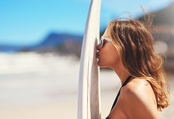 Ragazza che bacia tavola da surf