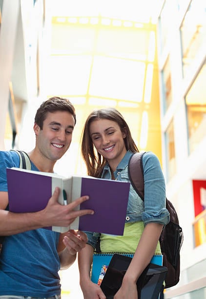 due studenti che guardano un libro insieme 