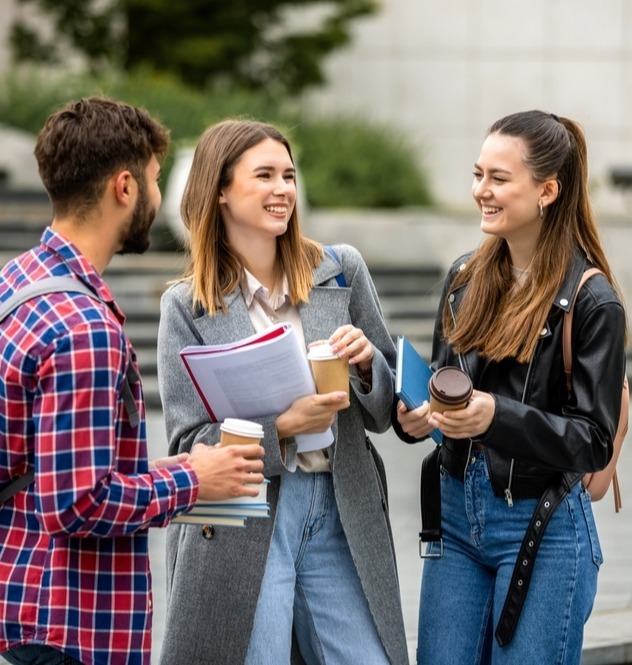 ragazzi che ridono con libri e caffé in mano
