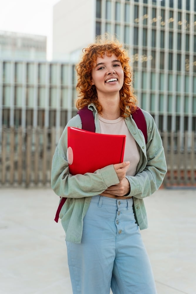 ragazza sorridente con libro in mano
